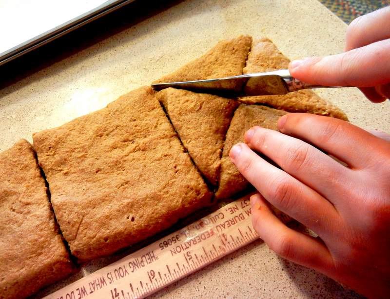cutting triangular scones with a butter knife.