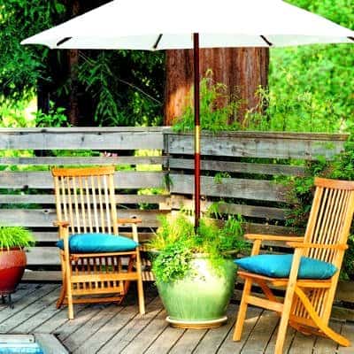 Creating Whimsy In Your Backyard & Garden, Part Two. A patio umbrella holder/planter in a shady reading area for outdoor living
