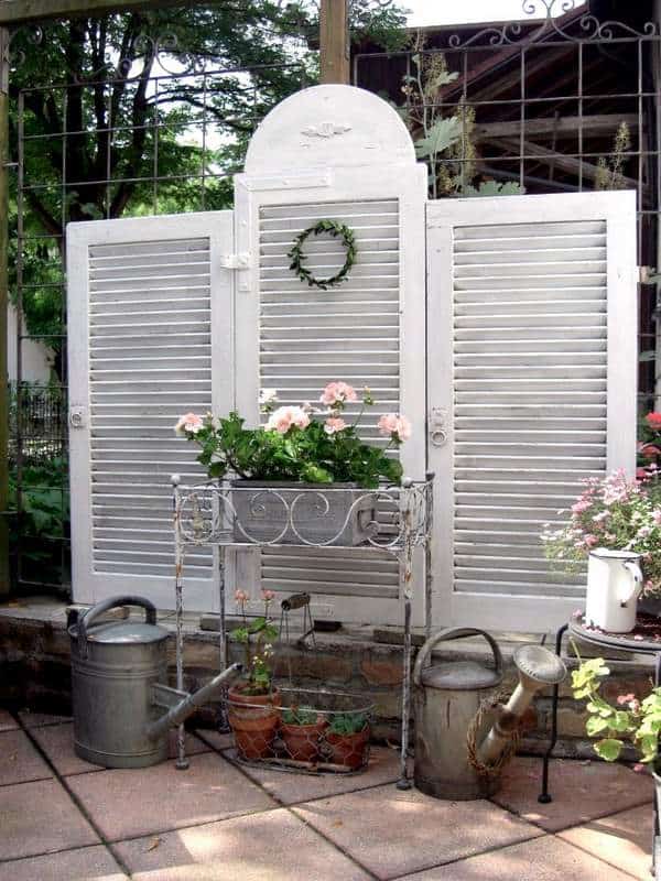 Creating Whimsy In Your Backyard & Garden, Part One. A clever louvered set of shutters as a privacy backdrop for patio or garden