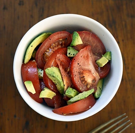 6 Tomato Health Benefits & Essential Summer Foods To Pair with Them. An avocado and fresh tomato salad.