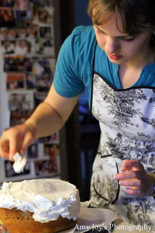 White Chocolate Raspberry Torte Recipe & Tutorial. Ana spreading icing