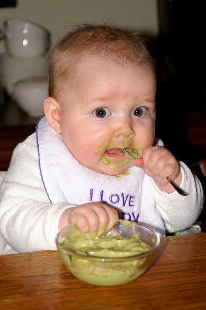 Avocados: Fabulous Ketogenic Recipes & 19 Health Benefits. baby eating with a spoon