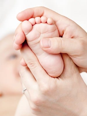 rubbing baby's feet, mother's hands