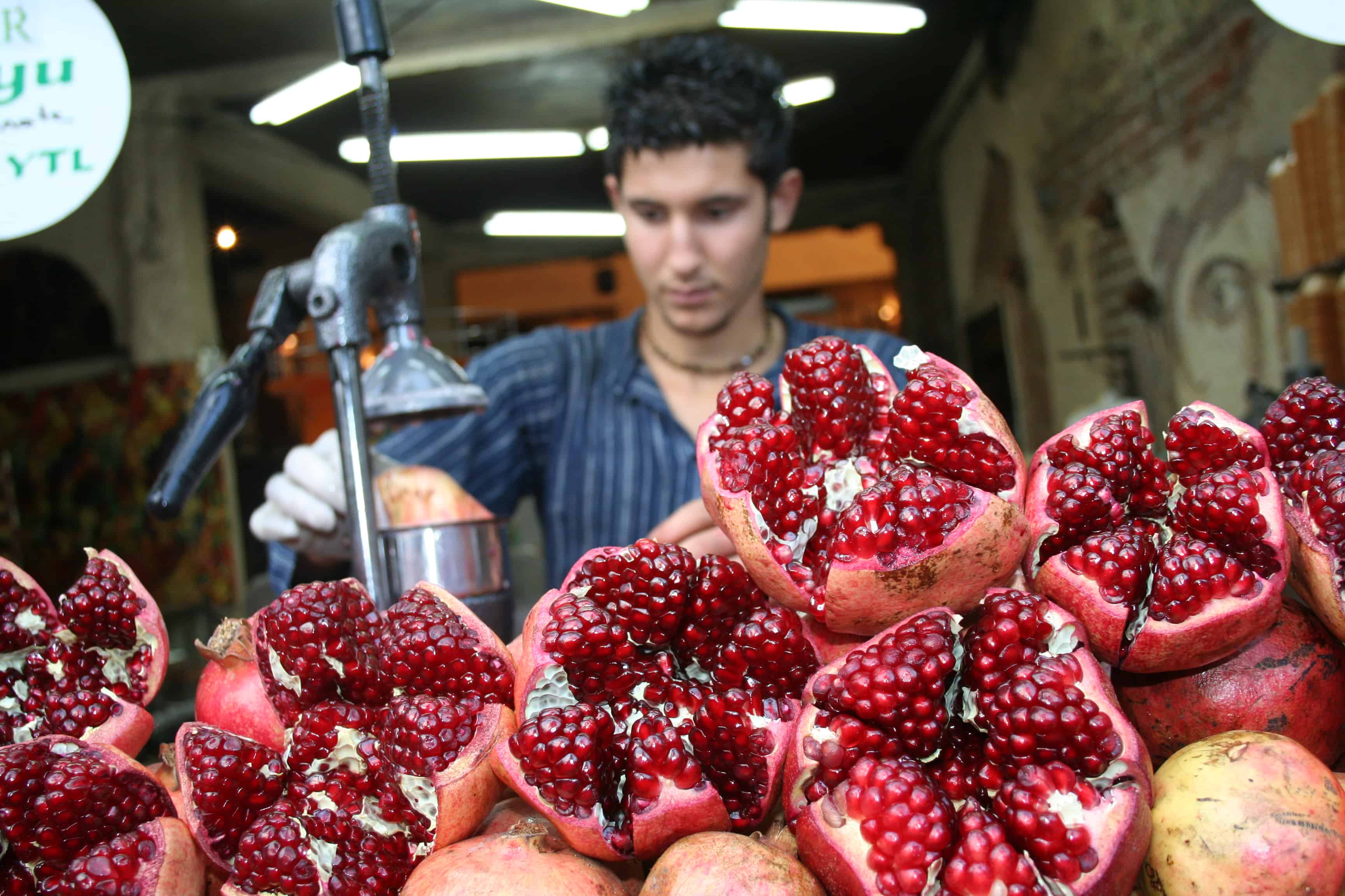 Research: Pomegranate Juice Reverses Heart Blockage. Man opening up pomegranates