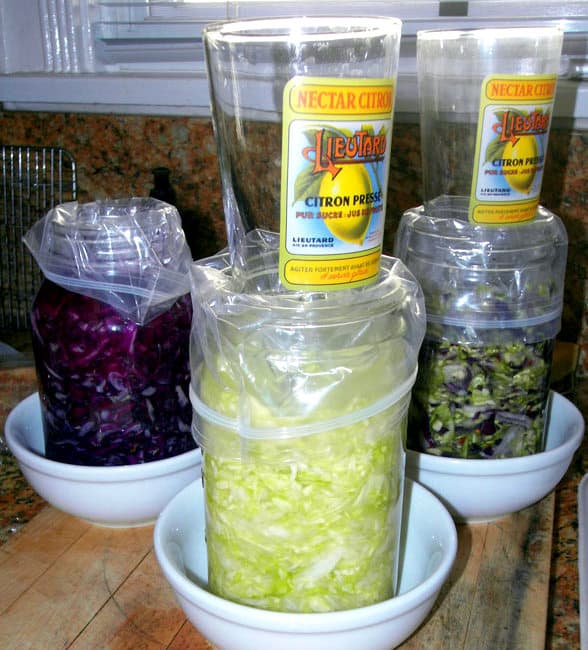 Step-by-Step Process Of Making Sauerkraut In a Crock, DIY, homemade, homemaking, keeper at home, choucroute, Eastern Europe, barrels, kitchen/postal scale, Sandor Katz, quote, books, French Grey salt, Himalayan pink salt, sea salt, minerals, shredded cabbage, chopped cabbage, independence, open crock, Boss Pickler, Fido jar, canning jars, mason jars, Ball jars, salt ratio, bon appetit, Alsace Lorraine, France, cellar, food storage, fermentation, big batches, crunchy, sour, kahm yeast, Holland, caraway seeds, lidded crock, Harsch crock, Gartopf, Germany, grandmothers, probiotic, Reuben sandwiches, flavor, crunchy, beneficial bacteria, bad bacteria, lactobacillus, lactic acid, Swabian village, brine, salt solution, lacto-fermentation, sustainable living, living off the grid, the old ways, thermometer, heated garage, food storage, pantry, kraut, ferment