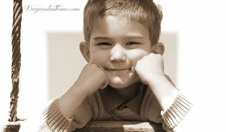 Boys Think, See, Hear & Process Very Differently Than Girls. A cute smiling 7-8 year old boy with his chin resting on hands.