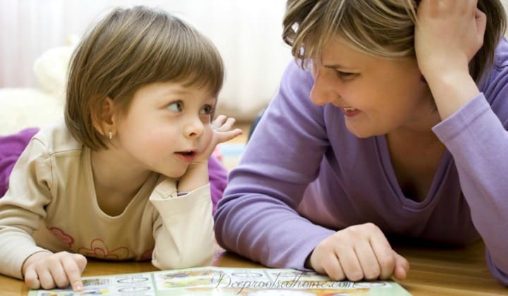 Parents, Kids, Great Books & The Bond Of Reading. A Mom and a toddler talking together as they read a book.