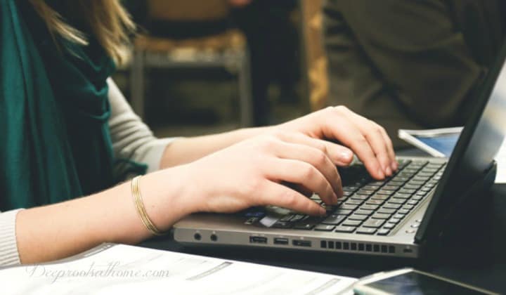 Is WebMD Still A Trusted Source Of Health Information? A woman sitting at a computer typing as she researches health information.