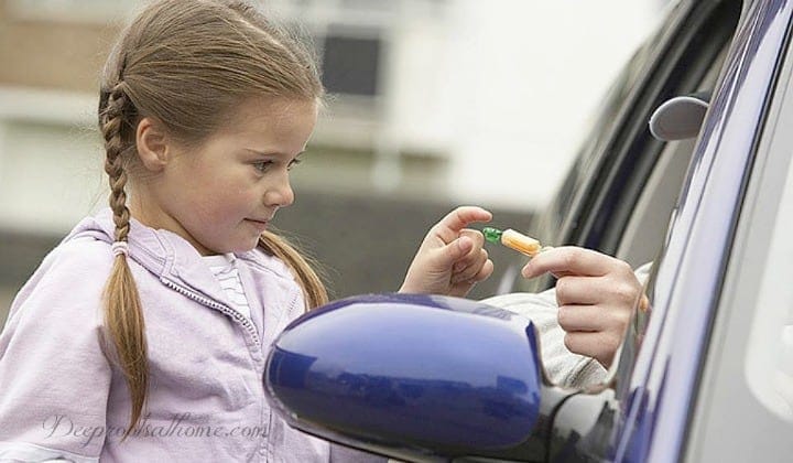 "Tricky People": What Your Kids Need To Know In This Culture. A young girl reaching for a piece of candy handed by someone out a car window. 