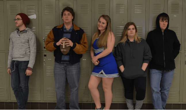5 kids standing by their lockers in a high school...looking bored. 