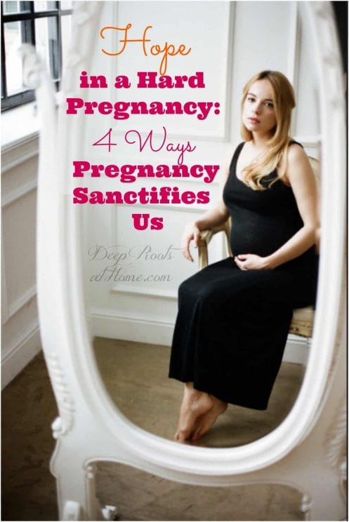 Hope In a Difficult Pregnancy: 4 Ways Pregnancy Sanctifies Us. A pregnant woman looking uncertainly into a full length mirror.