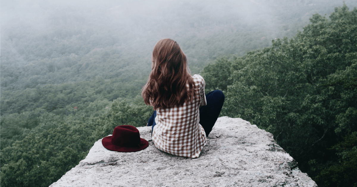 Pulling the Plug on Your TV and Liking It: A Radical Choice! Woman sitting on a high rock looking over the world