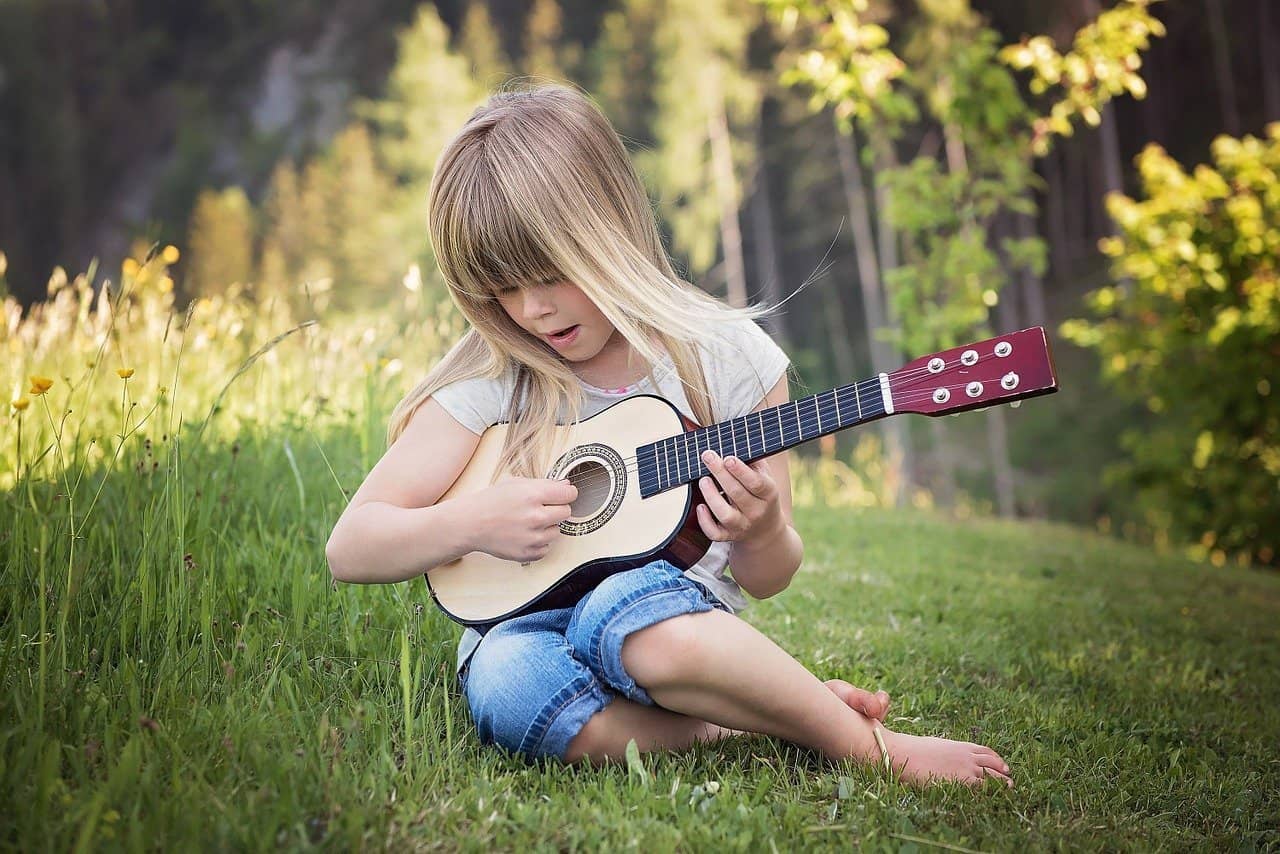25 Foundational Hymns To Teach Your Children While Young. girl with ukulele